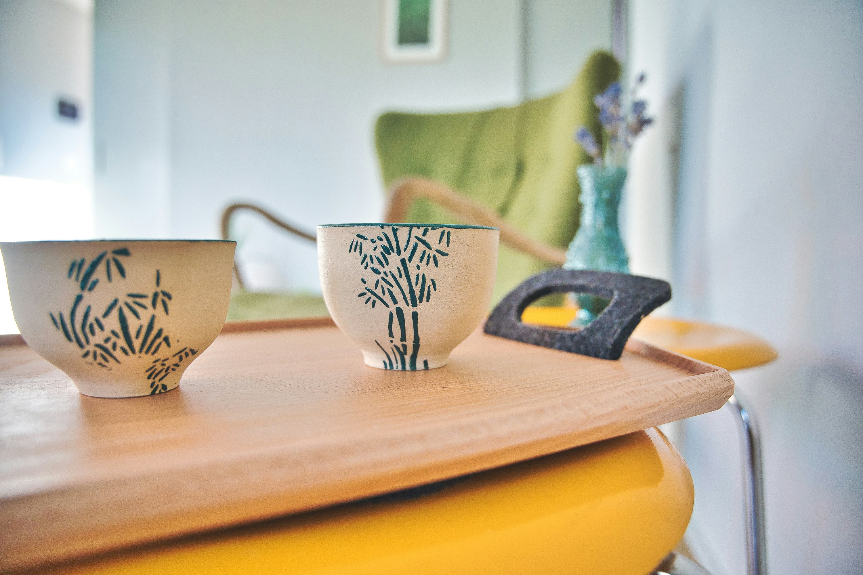 white and brown floral ceramic teacup on brown wooden chopping board